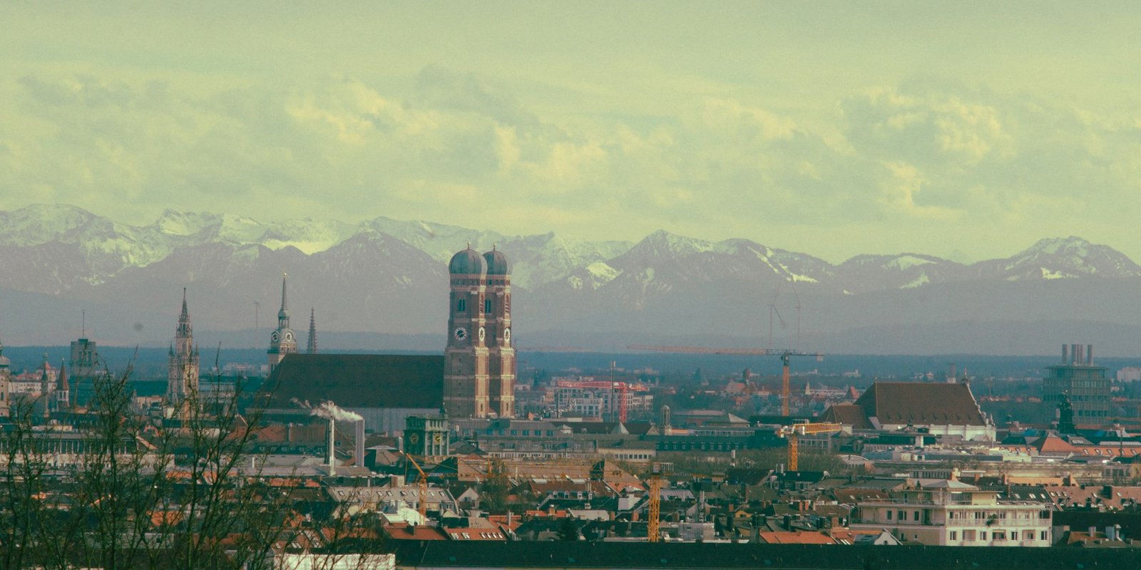 Münchner Altstadt mit Frauenkirche und den Alpen im Hintergrund